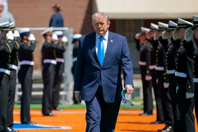 Trump caminando entre militares