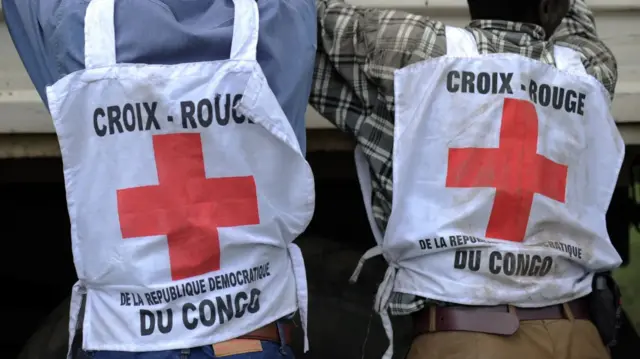 Abantu babiri bafotowe mu mugongo itaburiya za Croix-Rouge. Kuri izo taburiya handitse ngo: “Croix-Rouge de la République Démocratique du Congo”.