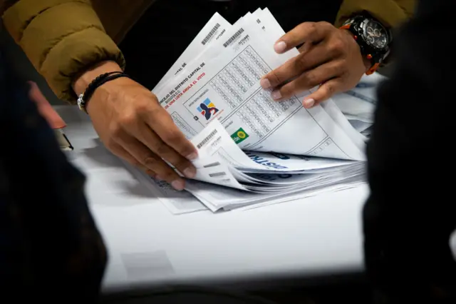 Una mujer cuenta papeletas de votación en Colombia