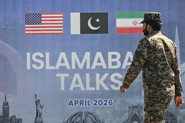 پر دیوال د ایران، پاکستان او امریکا بیرغونه رسم دي، لاندې ترې "اسلام اباد مذاکرات" لیکل شوي او یو پوځي هم هلته روان برېښي.