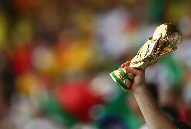 Mano en un estadio con al Copa del Mundo