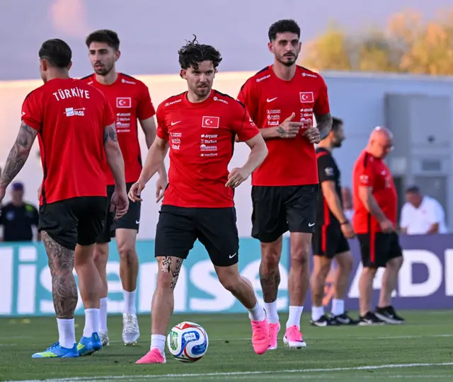Kırmızı siyah formalı futbolcular antrenman yapıyor