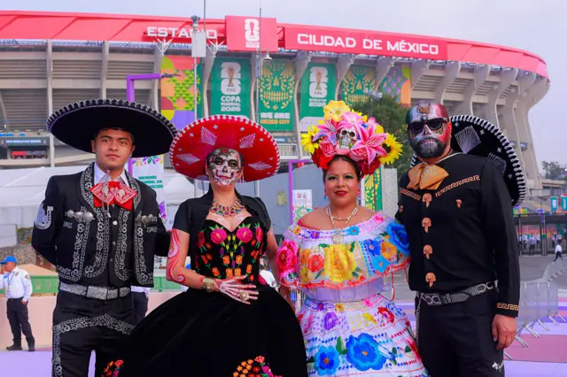 Cuatro personas vestidas con trajes tradicionales de México