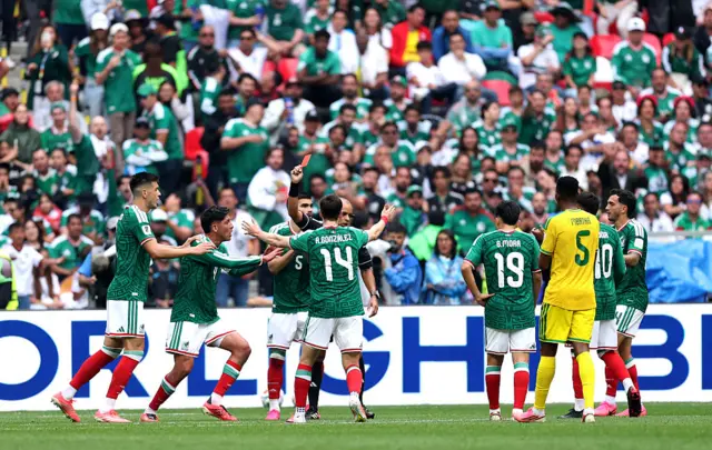 Árbitro mostrando cartão vermelho para jogadores do México