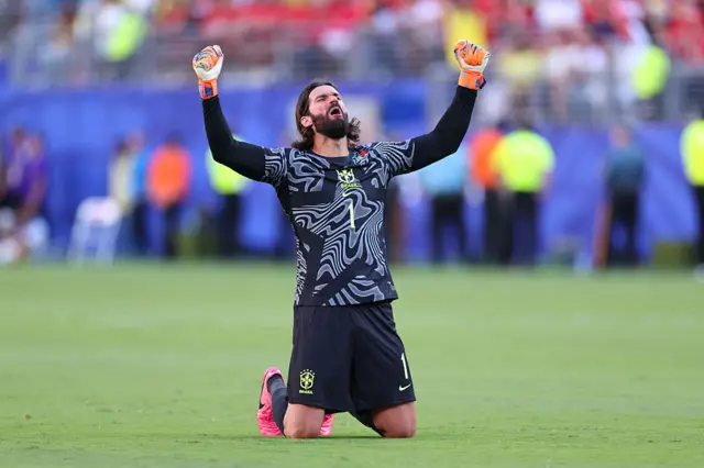 Alisson com as mãos levantadas para o céu