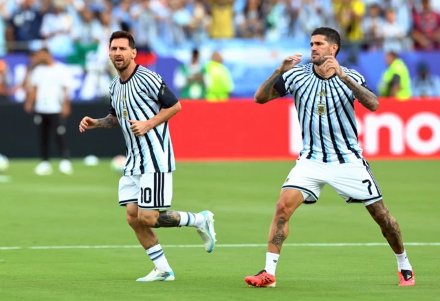 Messi y De Paul calentando