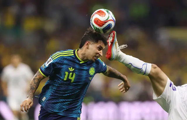 Gustavo Puerta y el pie de Abbosbek Fayzullaev compitiendo por el balón.