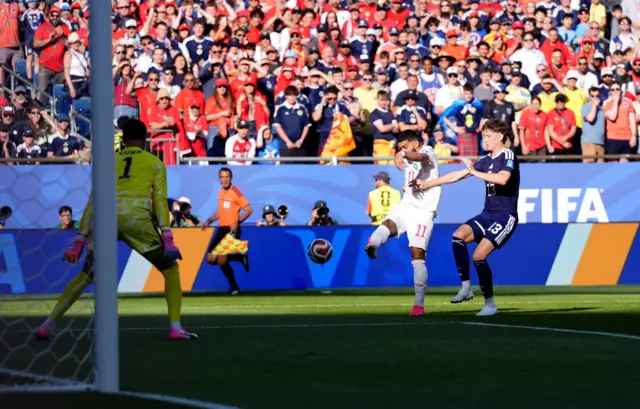 Jogador chuta bola em direção ao gol