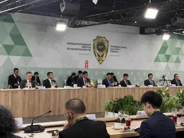 မေလ ၂၆ ရက်နဲ့ ၂၉ ရက်အတွင်းပြုလုပ်တဲ့ နိုင်ငံတကာငြိမ်းချမ်းရေးဖိုရမ်မှာတွေရတဲ့ ဦးတင်အောင်စန်း (စားပွဲတန်း တစ်ဖက်ခြမ်းက မြန်မာနိုင်ငံအလံငယ် အနောက်မှာမြင်ရတဲ့ မျက်မှန်တပ်အမျိုးသား)