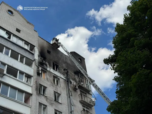 Дом с повреждениями на последних этажах.