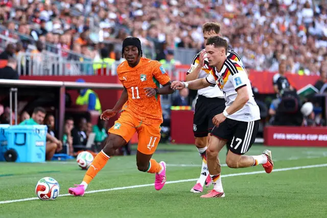 Yan Diomande contrôle le ballon face à Florian Wirtz