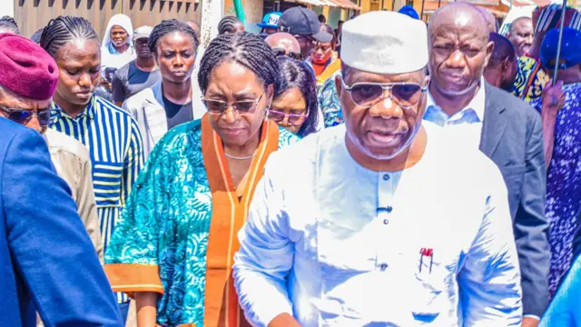 Man wey wear cap and white dress