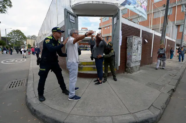 Policías revisan a ciudadanos en un centro de votación