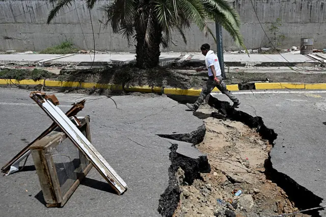 Un hombre pasa por una grieta surgida tras los terremotos en Venezuela