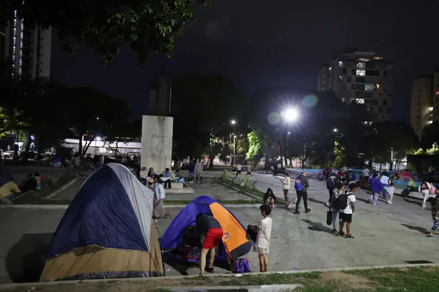 Personas duermen en una plaza en Caracas.