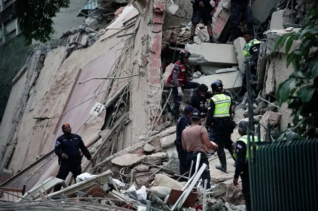 Rescatistas en medio de un edificios derrumbado