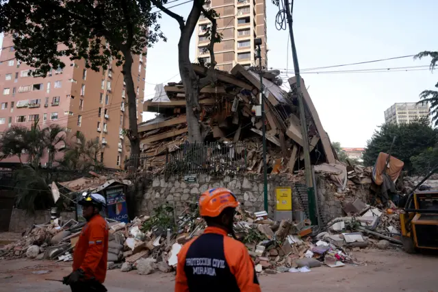 Servicios de rescate frente a un edificio colapsado en Caracas.
