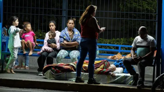 La gente espera en una parada de autobús en Caracas