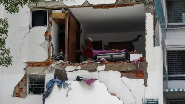 Una vista al interior de un apartamento con una pared colapsada