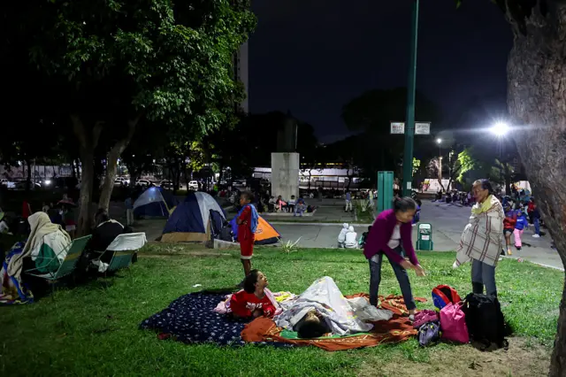 Personas duermen en un parque de Caracas.