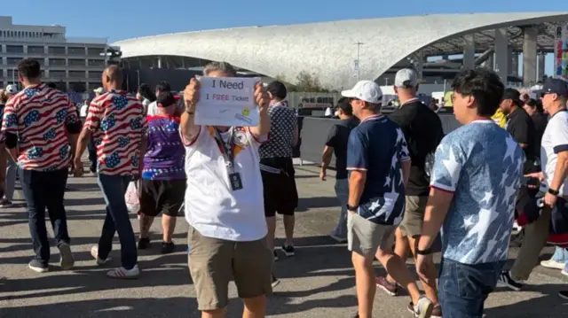 Bir taraftar "Bedava bilet lazım" yazılı bir döviz tutuyor