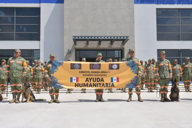 Militares sostienen un cartel que dice Ayuda humanitaria