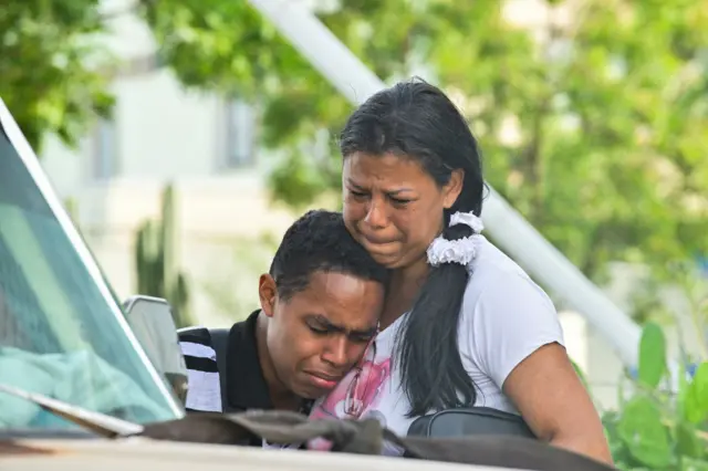 Dos personas lloran tras los terremotos que golpearon Venezuela el 24 de junio