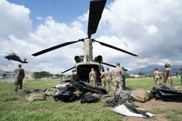 Militares de Estados Unidos junto a un helicóptero.