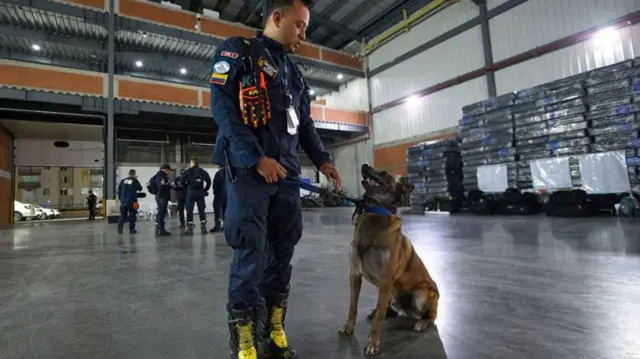 Un bombero colombiano con un perro de búsqueda y rescate antes de partir hacia Venezuela