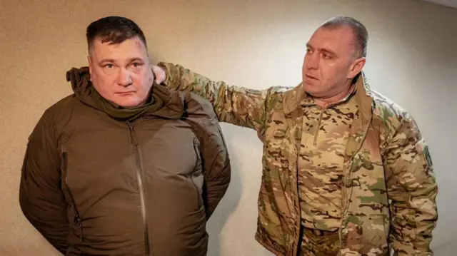Umukuru w’urwego rw’iperereza rwa Ukraine, Vasyl Malyuk (iburyo), yafotowe ari kumwe na Colonel Dmytro Kozyura inyuma y’aho afatiwe muri Ruhuhuma(2) 2025. Barahagaze amufashe ijosi.