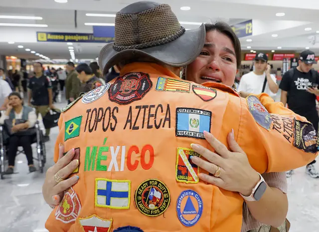 Integrante de Topos Azteca abrazando a una joven que llora