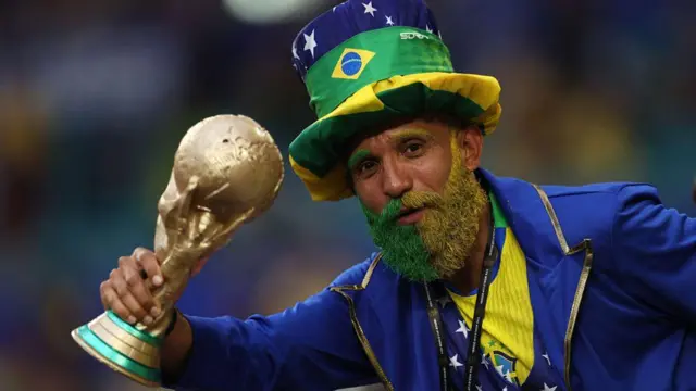 Wani fan na Brazil tare da gemu mai fentin da kuma kwafin kofin duniya