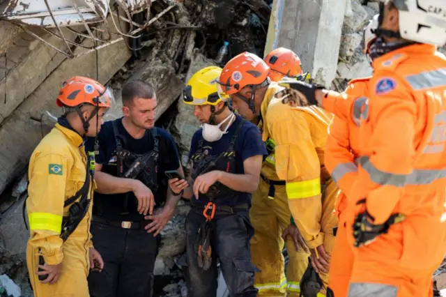 Equipos de rescate brasileños y franceses colaboran junto a un edificio dañado en Catia La Mar, en el estado de La Guaira.