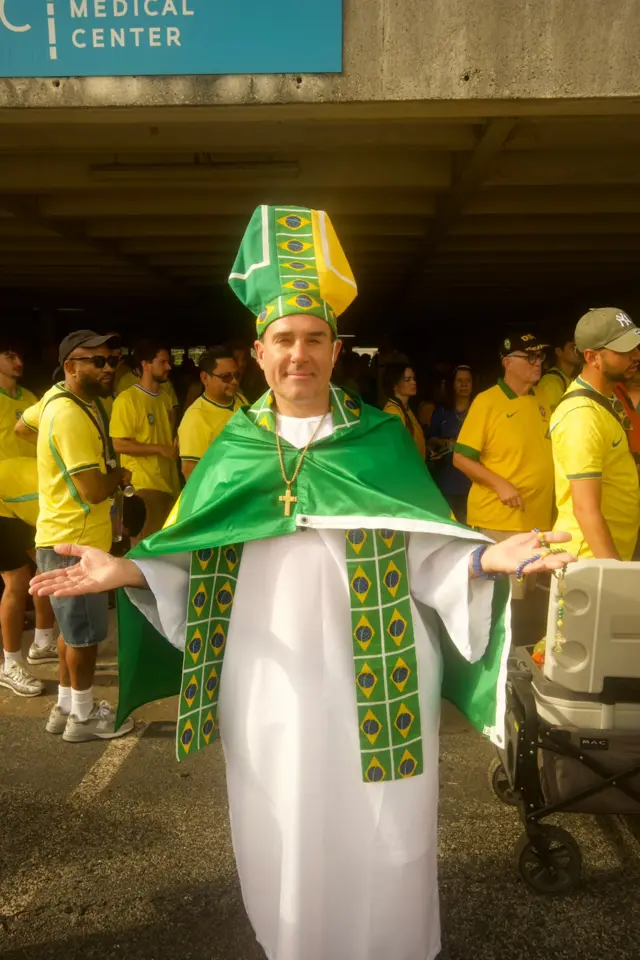 Homem vestido de padre com bandeira do Brasil