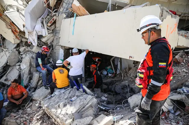 Rescatistas buscan entre los escombros de un edificio en Venezuela.