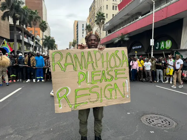 Muandamanaji akiwa na bango