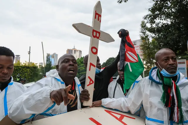 Abaharanira uburenganzira bambaye impuzu zibakingira indwara, bitwaje isandugu yanditseko ijambo “Ebola”, bariko biyamiriza iyubakwa ry’ikigo kizovurirwamwo abarwaye Ebola muri Kenya, i Nairobi, ku wa 2 Ruheshi (6) mu 2026.