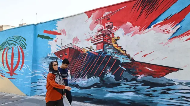 ایران میں دیوار پر ایک خاکہ جس میں بحری جہاز پر میزائل برستے دکھائے گئے ہیں