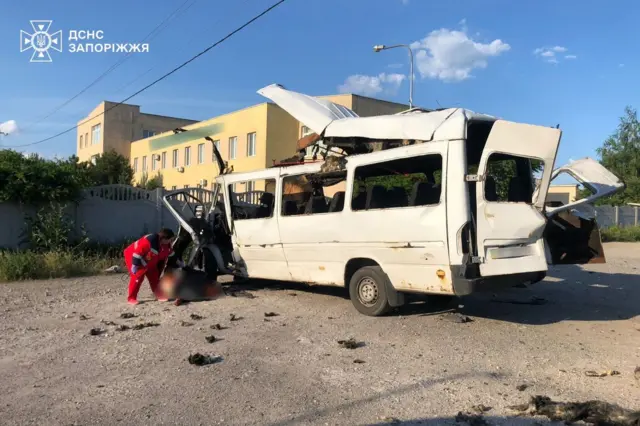 Автобус, пострадавший в результате удара, видны спасатели, извлекающие погибшего из машины