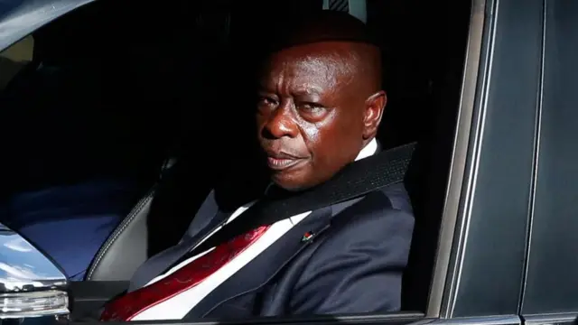 Rigathi Gachagua yicaye mu modoka, yambaye ikositimu y’umukara, ishati y’umweru na karuvati itukura (ifoto mbarankuru yo mu bubiko)
