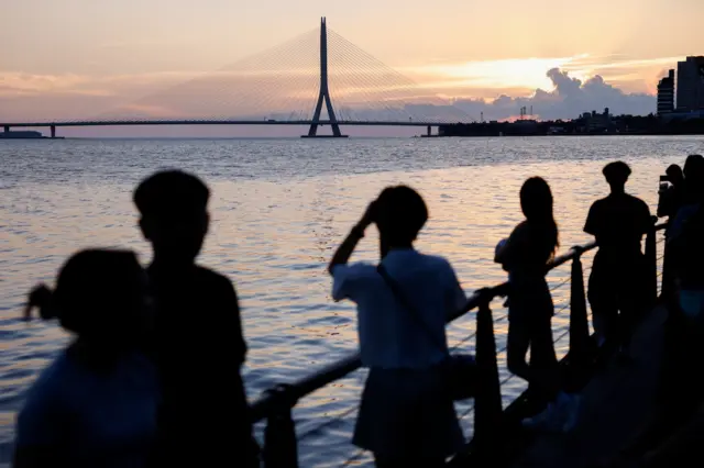 2026年7月9日，民眾在淡江大橋附近欣賞夕陽，颱風巴威即將逼近。