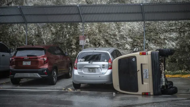 美屬關島上某處停車場，一輛麵包車在颱風巴威吹襲期間被掀翻（6/7/2026）