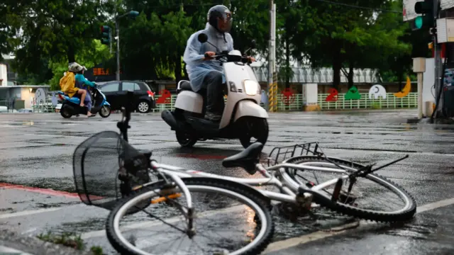 颱風下台灣花蓮街頭一輛自行車被遺棄馬路上，背景有摩托車照常行駛（11/7/2026）