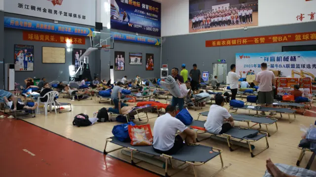 浙江溫州蒼南縣靈溪鎮文體中心避災安置點內被疏散民眾坐在帆布床上休息(中新社圖片10/7/2026)