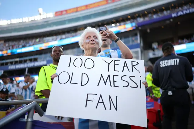 Pauline Kana sostiene un cartel que dice "Fan de Messi de 100 años de edad",