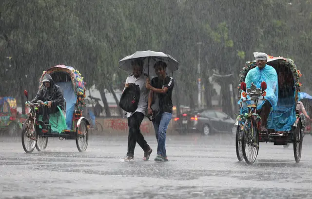 বৃষ্টিতে ভিজে ঢাকা বিশ্ববিদ্যালয়ের টিএসসিতে যাচ্ছেন দুই শিক্ষার্থী