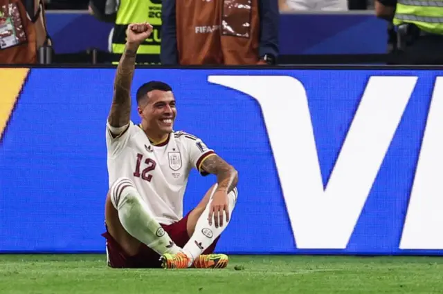 Porro sentado no chão comemorando gol