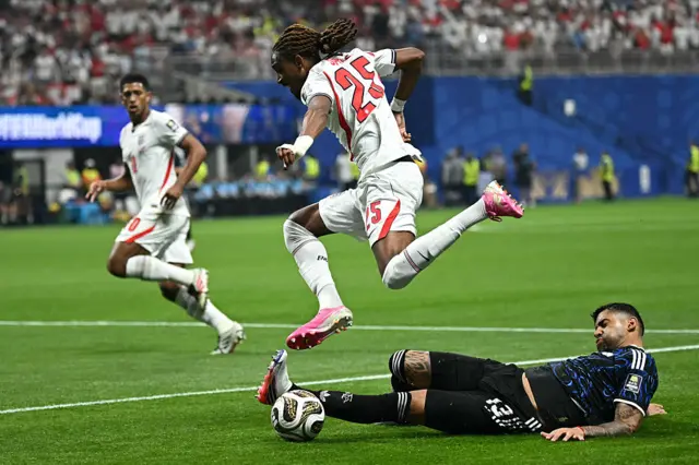 O defensor da Inglaterra nº 25 Djed Spence (à esquerda) e o defensor da Argentina nº 13 Cristian Romero disputam a bola durante a partida da semifinal da Copa do Mundo de 2026 entre Inglaterra e Argentina, no Atlanta Stadium, em Atlanta, em 15 de julho de 2026. (Foto de Paul ELLIS / AFP via Getty Images)