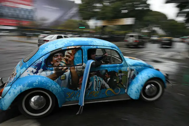 ülkenin hayatını kaybeden futbol efsanesi Diego Maradona ile Arjantinli yıldız Lionel Messi’nin görselleriyle süslenen bir Volkswagen Beetle sokakta ilerliyor