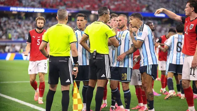 Arbitres entourés de joueurs argentins.